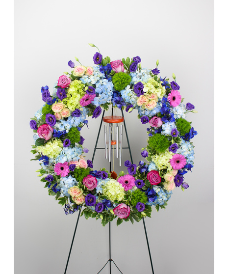 Garden song is a beautiful standing wreath with a keepsake windchime in remembrance of your loved one.