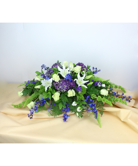 Heavenly Hillside Casket Spray is a serene tribute that captures the tranquil beauty of nature's rolling hillsides.